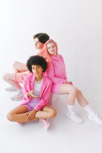 From above of happy teenage multiracial girls and boy in stylish outfits on white background of studio